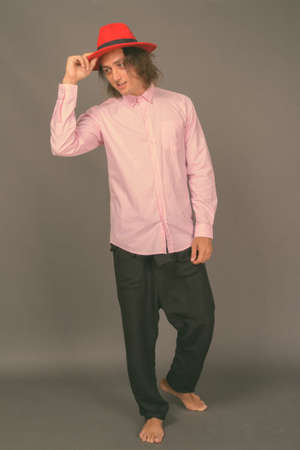 Portrait of young handsome man against gray backgroundの写真素材