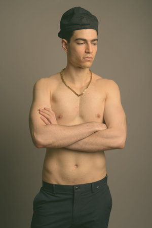Young handsome man shirtless against gray background