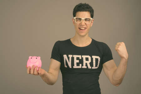 Young handsome nerd man with eyeglasses against gray backgroundの写真素材