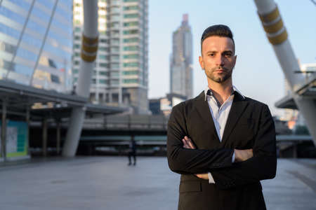 Handsome young businessman outdoors in city looking at cameraの写真素材