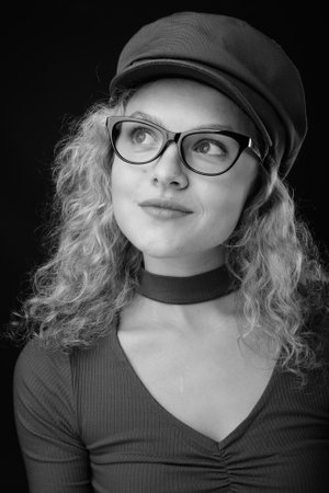 Young beautiful woman with blond curly hair against gray backgroundの写真素材