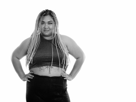 Studio shot of young happy fat Asian woman smiling with hands on hipsの写真素材
