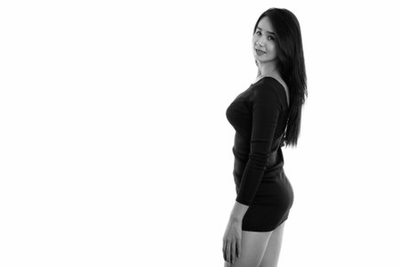 Studio shot of young happy Asian transgender woman smiling while looking backの写真素材