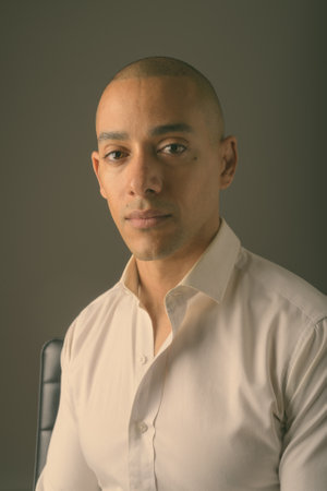 Handsome bald businessman against gray backgroundの写真素材
