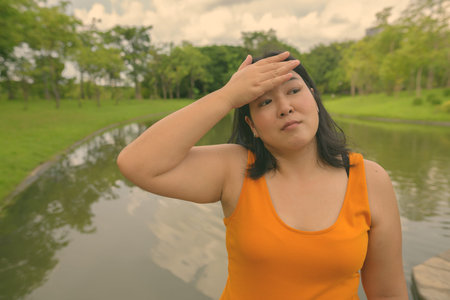 Beautiful overweight Asian woman relaxing at the park in the city of Bangkok, Thailandの写真素材