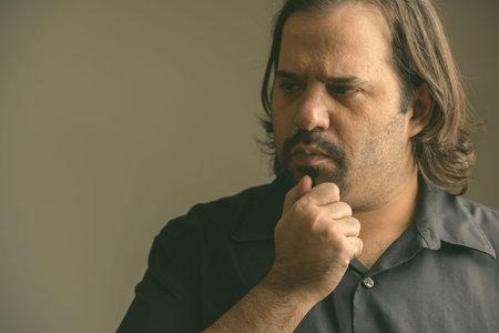 Close up of fat Caucasian man thinking in the dark