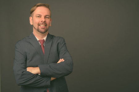 Blond bearded businessman with goatee against gray background