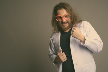 Young bearded man doctor against gray backgroundの写真素材