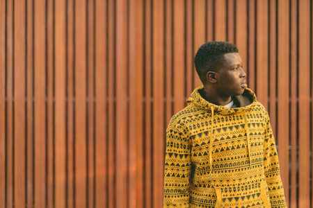 Profile view of young black African man thinking against wooden gateの写真素材