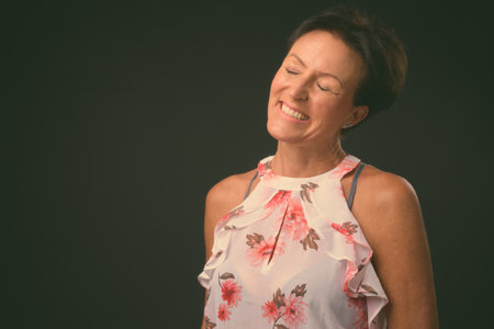 Mature beautiful woman with short hair against black backgroundの写真素材