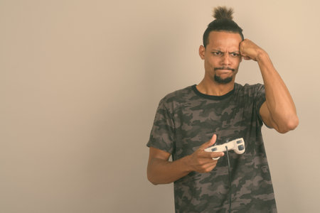 Young bearded handsome African man against gray backgroundの写真素材