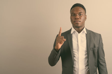 Young African businessman wearing suit against white backgroundの写真素材