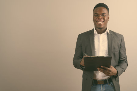 Young African businessman wearing suit against white backgroundの写真素材