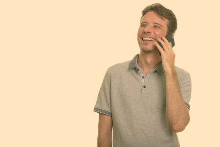 Happy Caucasian man talking on mobile phoneの写真素材