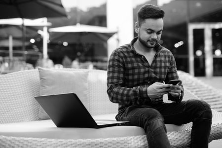 Young bearded Indian businessman shot in black and whiteの写真素材