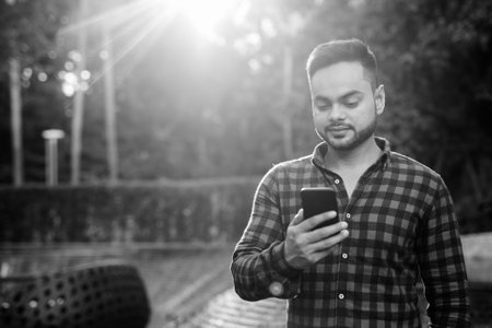Young bearded Indian businessman shot in black and whiteの写真素材