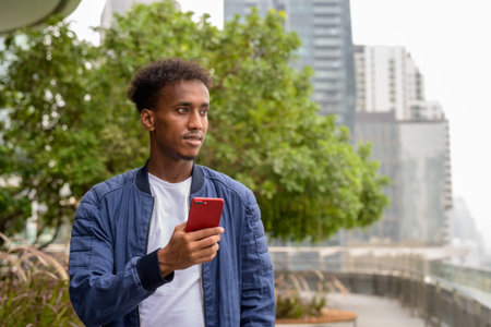 Portrait of handsome black African man at rooftop garden