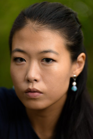 Close-up portrait of beautiful rebel Asian woman face outdoors