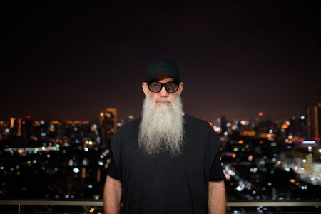 Portrait of mature man with gray beard outdoors at night