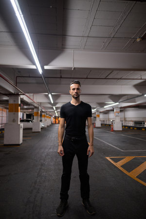 Full length shot of handsome man at night at parking lot standing