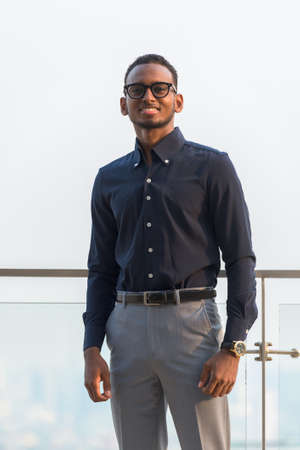 Portrait of handsome African businessman outdoors at rooftop in Bangkok, Thailandの写真素材
