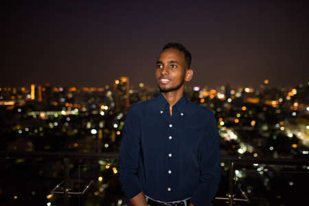 Portrait of handsome African businessman outdoors at rooftop in Bangkok, Thailandの写真素材