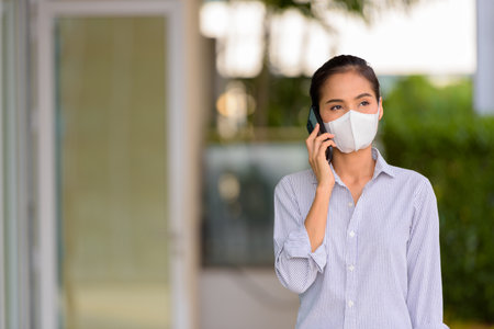 Asian woman wearing face mask to protect from coronavirus Covid-19 horizontal shotの写真素材