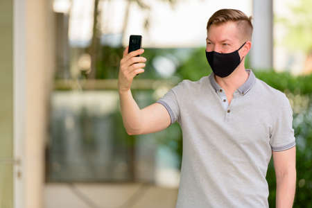 Man wearing face mask to protect from coronavirus Covid-19 outdoorsの写真素材