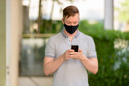 Man wearing face mask to protect from coronavirus Covid-19 outdoorsの写真素材