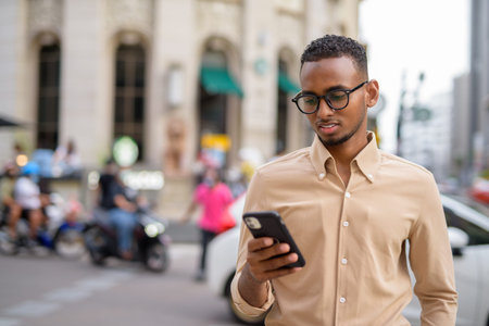 African businessman outdoors in city using mobile phoneの写真素材
