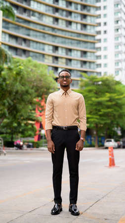 Full length shot of happy African businessman outdoors in cityの写真素材