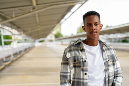 Portrait of African black man outdoors in city during summer horizontal shot