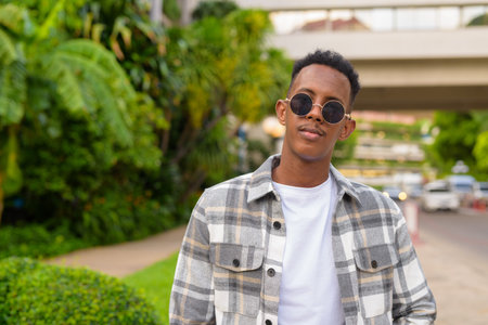 Portrait of African black man outdoors in city during summer horizontal shot