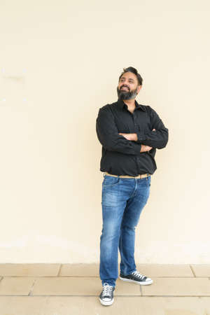 Portrait of handsome Indian man against plain backgroundの写真素材