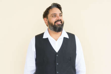 Portrait of handsome Indian businessman against plain backgroundの写真素材