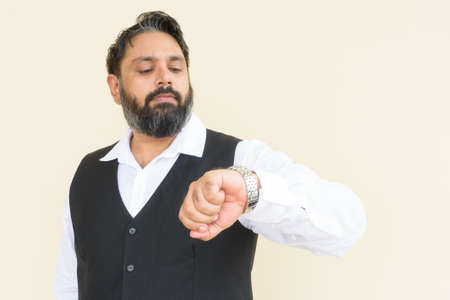 Portrait of handsome Indian businessman against plain backgroundの写真素材