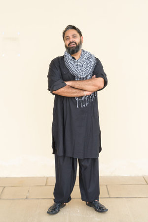 Portrait of handsome Indian man against plain background