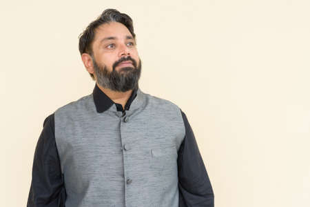 Portrait of handsome Indian businessman against plain backgroundの写真素材