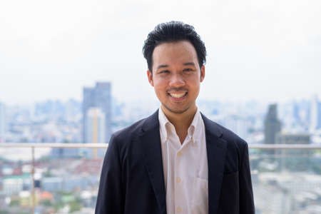 Portrait of man Asian businessman wearing suit outdoors in Bangkok, Thailandの写真素材