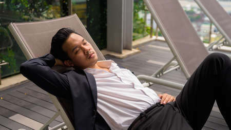 Portrait of man Asian businessman wearing suit and relaxing outdoorsの写真素材