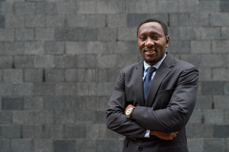 Portrait of handsome African businessman outdoors in city