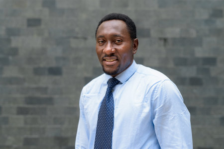 Portrait of handsome African businessman outdoors in city