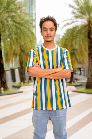 Portrait of handsome young man wearing colorful shirt outdoors during summerの写真素材