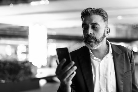 Portrait of handsome Indian businessman in city wearing suit