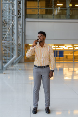 Full length portrait of young handsome African businessman in city vertical shot