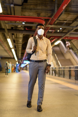 Full length portrait of young handsome African businessman in city vertical shotの写真素材