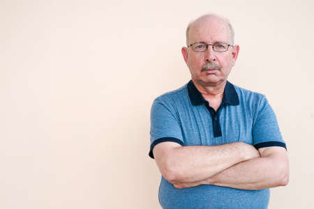 Portrait of senior man looking at camera with arms crossedの写真素材