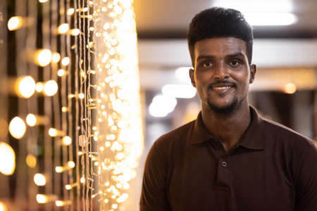 Portrait of young handsome black man in city at nightの写真素材