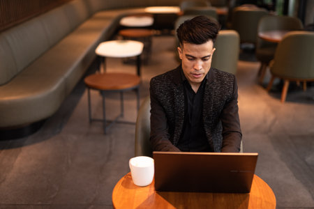 Young businessman using laptop computer in coffee shopの写真素材