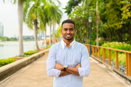 Portrait of handsome young black businessman at park outdoors during summerの写真素材